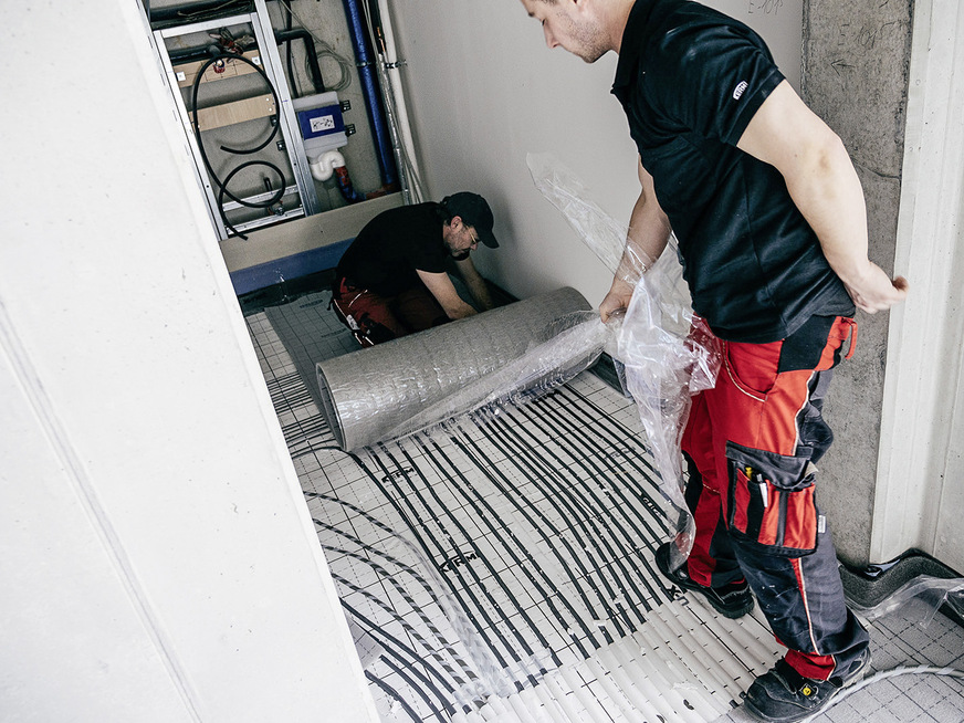 Um aufgrund der zahlreichen Rohrleitung in den Anschlussräumen eine optimale Dämmung zu gewährleisten, wurden in diesem Bereich die Klettrohre der Heizkreis in den Fluren ebenfalls in die Systemplatte eingelassen und abschließend bedeckt. Somit ist auch hier eine maximale Wärmedämmung gegeben