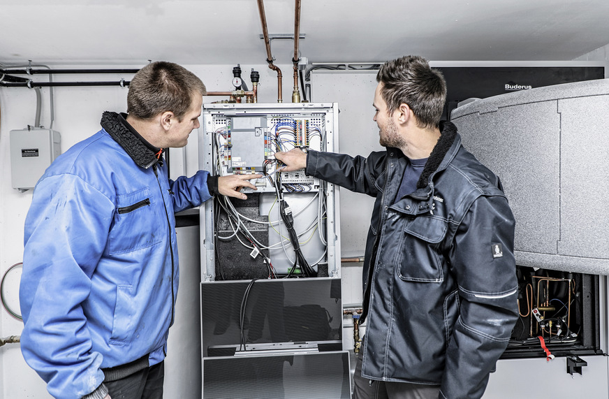 Frieder Brendle (links), Projektleiter der Heizungsfachfirma Wörner, lässt sich von Marvin Krohmer Details der Buderus Wärmepumpe Logatherm WLW196i erklären.