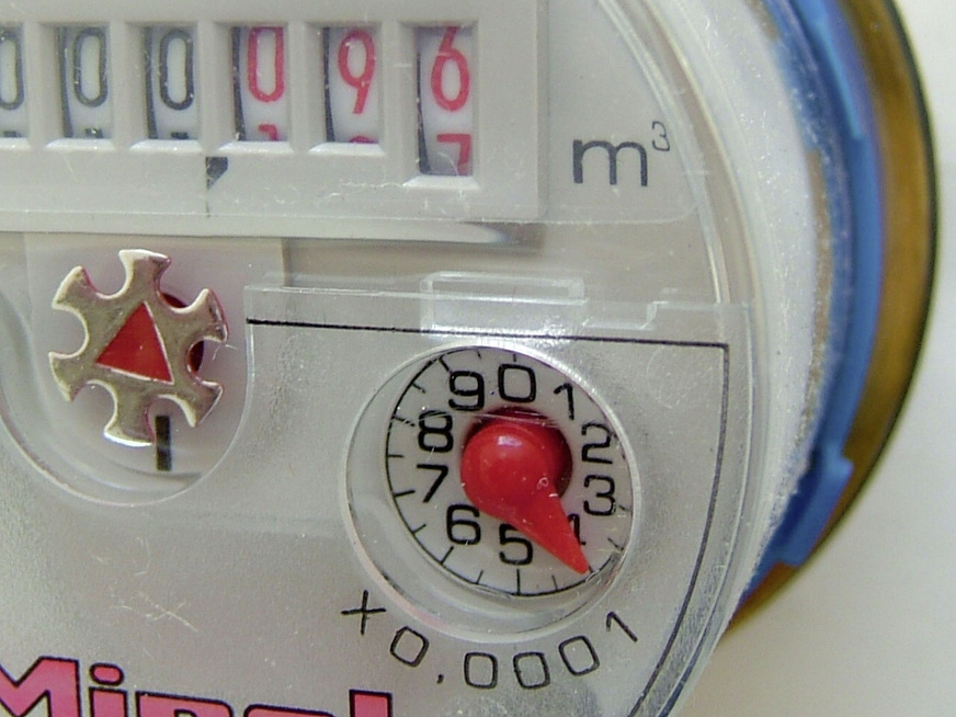 Wasserzähler in der Leitung zur Nachspeisung bei leerem Regenspeicher. Die anteilige Abwassergebühr des für die Bewässerung genutzten Trinkwassers wird vom Versorgungsunternehmen auf Antrag erstattet.