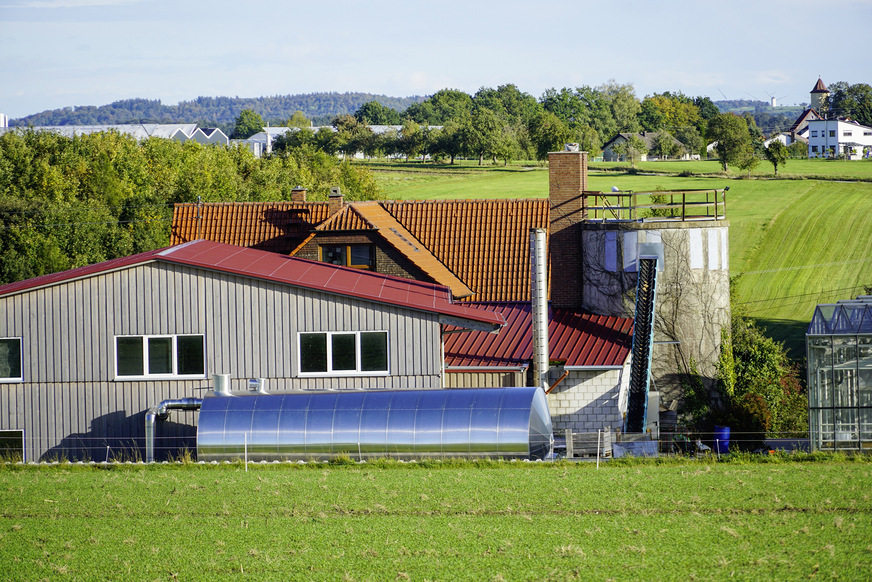 Zwei Energiespeicher: Im Vordergrund der blitzblanke Pufferspeicher und rechts der Hackschnitzeltank mit der sogenannten Rührwerksfederaustragung