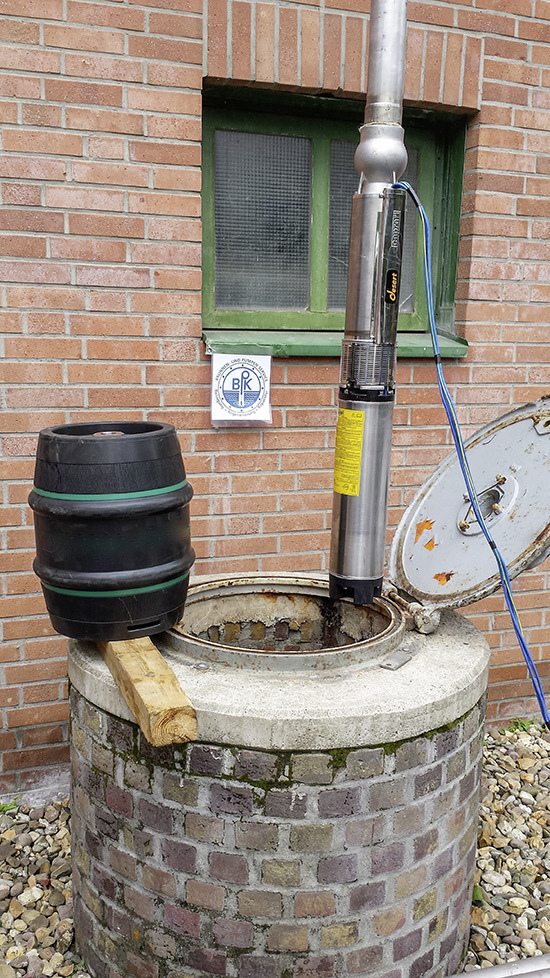 Einfahren der Pumpe samt Steigrohr in den Brunnen: der letzte Arbeitsschritt vor der Wiederinbetriebnahme