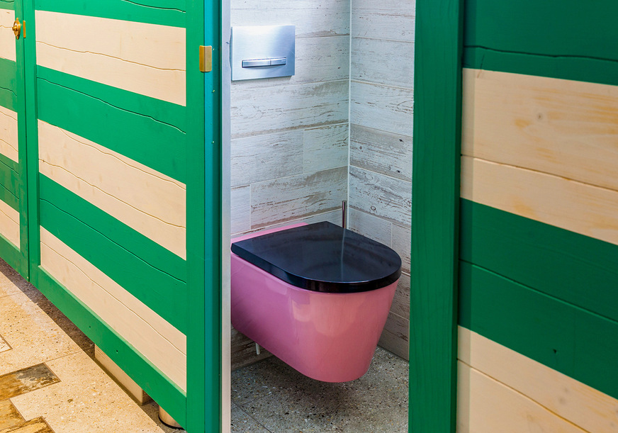 Die WC-Kabinen sind wie alte Strandumkleiden gestaltet, die pinkfarbenen Kartell - Laufen WCs setzen dazu einen vergnüglichen optischen Kontrapunkt.