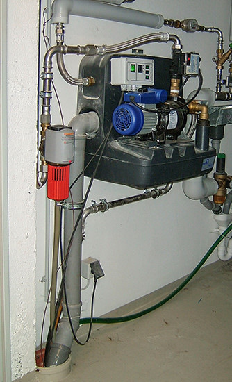 Falsch: Hauswasserwerk mit nur einer Pumpe bietet für ein Mehrfamilienhaus zu wenig Sicherheit. Filter (rote Abdeckung) nach dem Regenspeicher vermeiden!