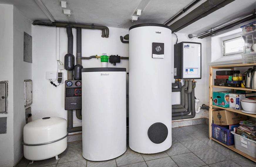 Anstelle der alten Gasheizung und eines gasbetriebenen Warmwassererzeugers bestimmen heute der 200-Liter-Pufferspeicher (li.) und der 300-Liter-Trinkwasserspeicher vom Typ uniSTOR plus sowie die wandhängende Inneneinheit der Wärmepumpe das Bild im Heizungskeller.