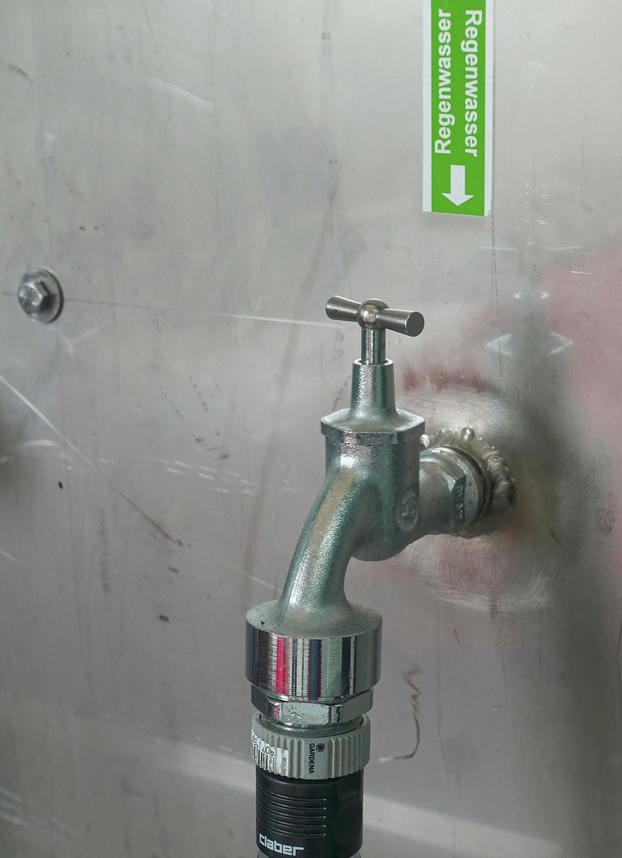 Kennzeichnung einer Entnahmestelle nach Vorgaben der DIN EN 16941-1, um Verwechslungen mit Trinkwasser durch die Nutzer zu verhindern. Dieses Ventil ist an einem großen Waschbecken installiert, das zur Reinigung von Bauteilen in der Produktionshalle dient.