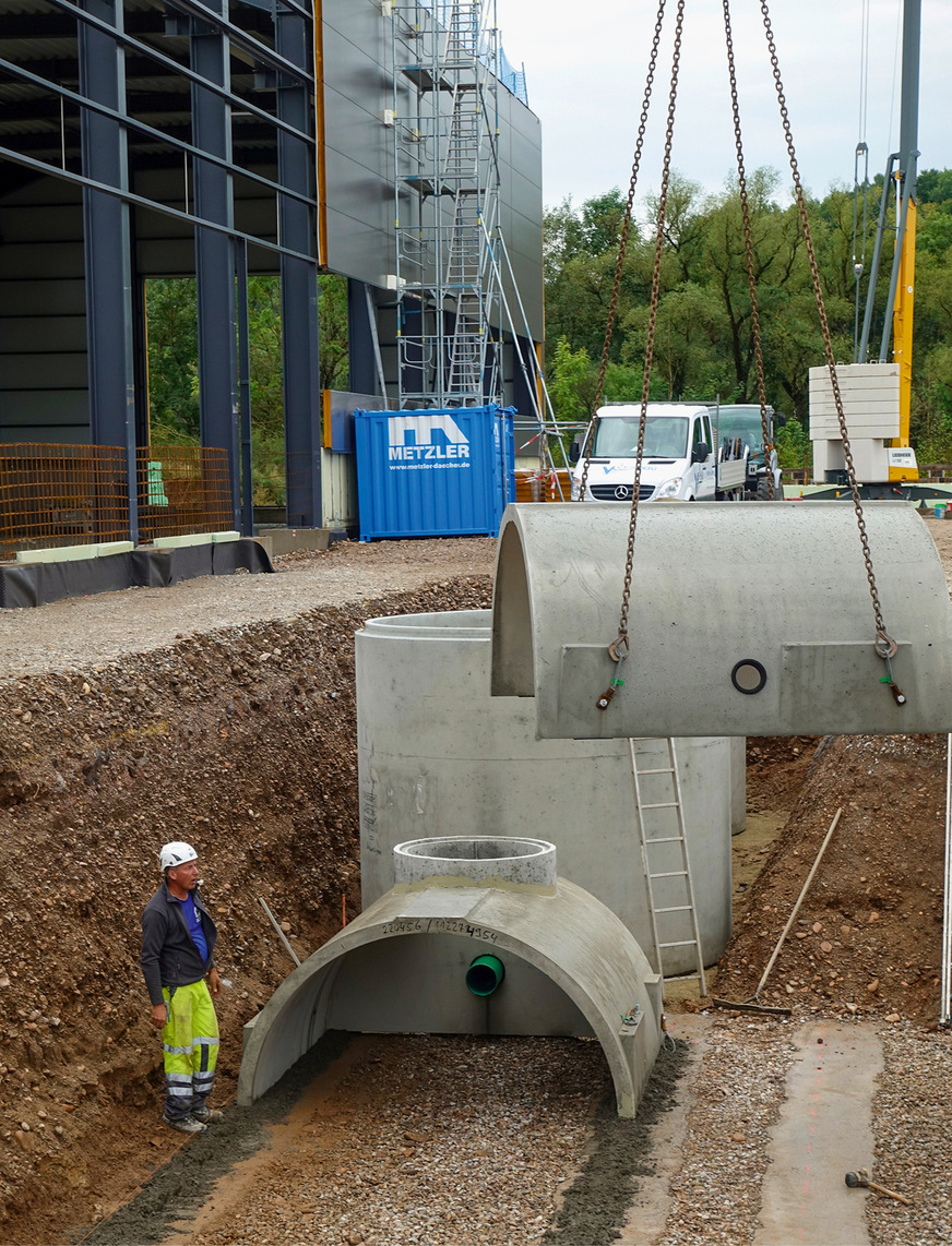 Montage der Betonfertigteile zu einem unterirdischen Sickertunnel. Im Hintergrund der Substratfilterschacht, der neben mineralölhaltigen Kohlenwasserstoffen auch Feststoffe wie Reifenabrieb und die Schwermetalle Kupfer und Zink aus dem Wasser entfernen kann.
