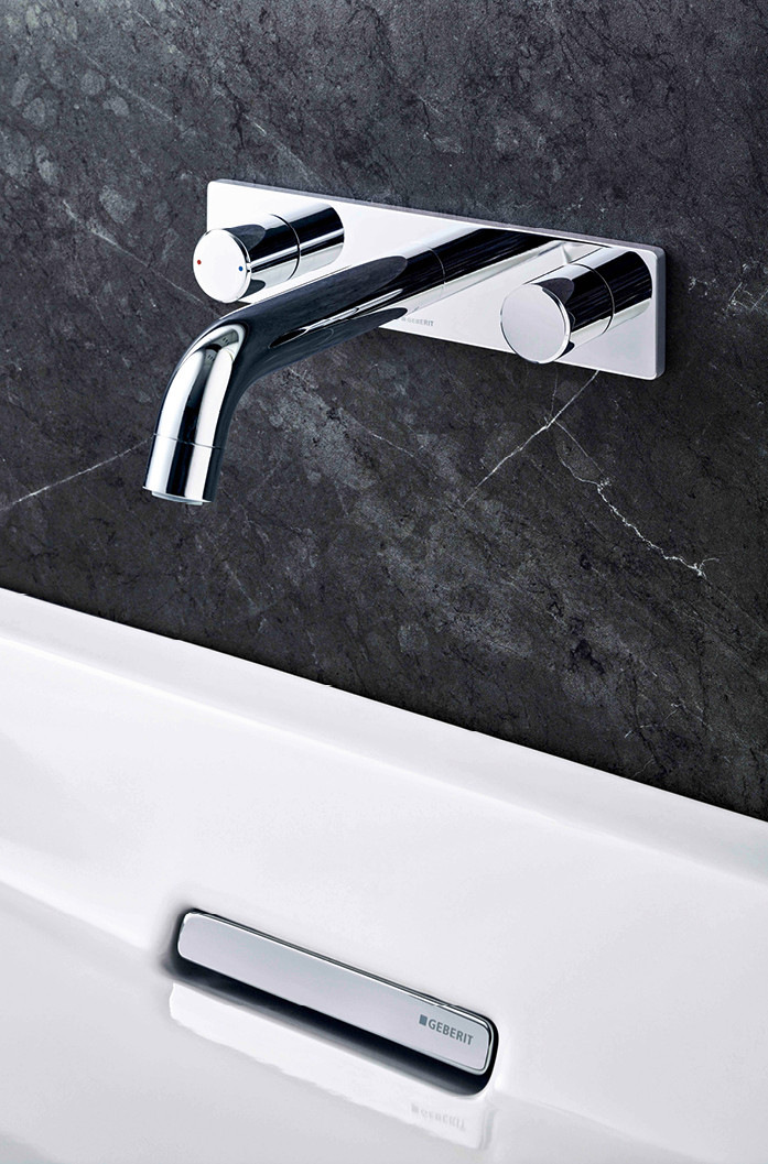 Oft sind es kleine Kunstwerke, die den Waschtisch-Platz verschönern; wie hier. Elegante Wandarmatur mit dazwischen genug Platz, um sich die Hände zu waschen.