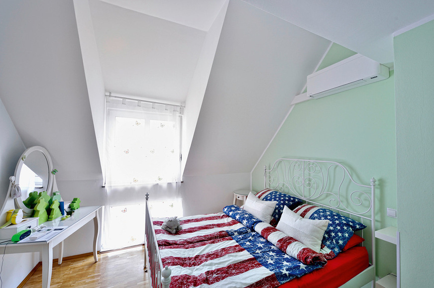 Das andere Klimagerät hat trotz des spitzen Dachverlaufs über dem Kopfende des Bettes im Schlafzimmer Platz gefunden.