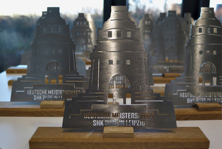 Die Siegerpokale der Deutschen Meisterschaft SHK 2025: Das Völkerschlachtdenkmal als Edelstahl-Trophäe.