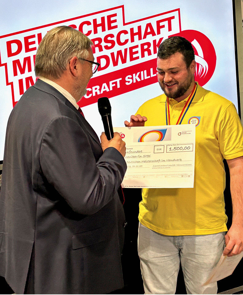 Hans-Werner Eschrich (Vorstand Bildung und Berufsförderung im ZVSHK) übergibt die Auszeichnung für den 1. Platz an Ben Nopper.