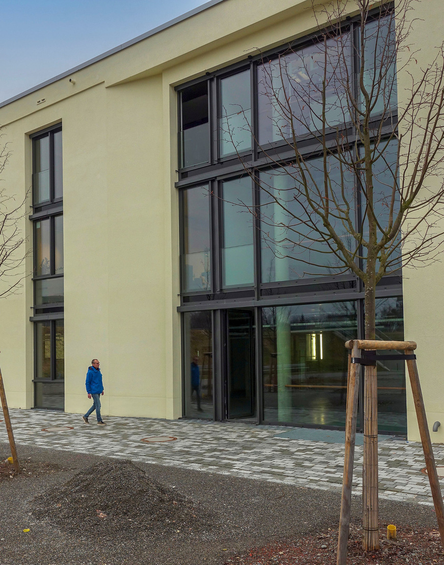 Südfassade mit Vorplatz der Carderie in Wangen/Allgäu, einem ­Industriegebäude Baujahr 1913 nach Umbau und Erweiterung. Unter dem Pflasterbelag sitzt der ­Regenspeicher, bestehend aus fünf Behältern und einem Filterschacht, jeweils durch Abdeckungen der Klasse D&nbsp;400 für Lkw und Feuerwehr befahrbar.