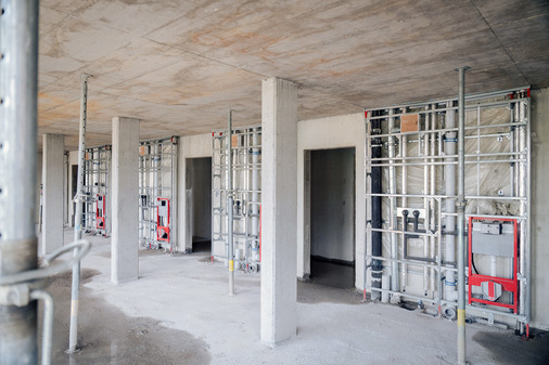  Blick auf eine Etage mit fertig installierten Installationswänden und der ausgehärteten Filigrandecke, die das Stockwerk nach oben hin abschließt.