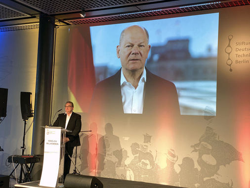 Bundeskanzler Olaf Scholz richtet ein Grußwort an die Gäste. Links: Oliver Kalkofe. Der Komiker, Kabarettist und Satiriker führte durch den Abend mit spitzen, satirischen Worten.