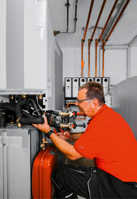 Blick hinter die Verkleidung des Hybridcenters. Die Komponenten sind das ­Innengerät der Wärmepumpe (vorne, oben), 300-Liter-Warmwasserspeicher 
(im Hintergund), Trennspeicher (vorne, unten), Ausdehnungsgefäß (vorne, unten, rechts) und die Komponenten für die Hydraulik und Steuerung.