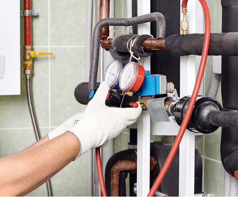 Der Installateur montiert ein Differenzdruckmessgerät für das Heizsystem eines Hauses.