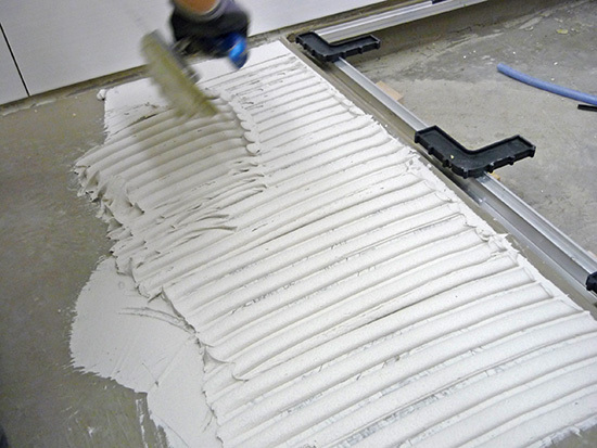 13.) Aufziehen des Sopro Klebers und Verlegen des Oberbelags