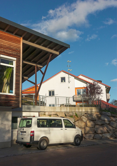 Michael-Gemeinschaft e. V., eine Jugendhilfeeinrichtung im Landkreis Lörrach, 2019 von Öl auf Holzpellets umgestellt. Hinten das Bestandsgebäude, links der Neubau mit Saal. Im Hang hinter der Natursteinmauer ist das Pelletlager integriert.