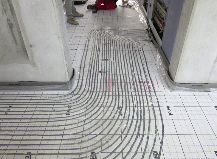 Dieses Bild zeigt, wie die durchlaufenden Leitungen ab Verteiler innerhalb der Dämmebene geführt werden. Die Durchgangsräume werden daher nicht oder nur moderat fremdbeheizt. - © Bild: Kermi GmbH
