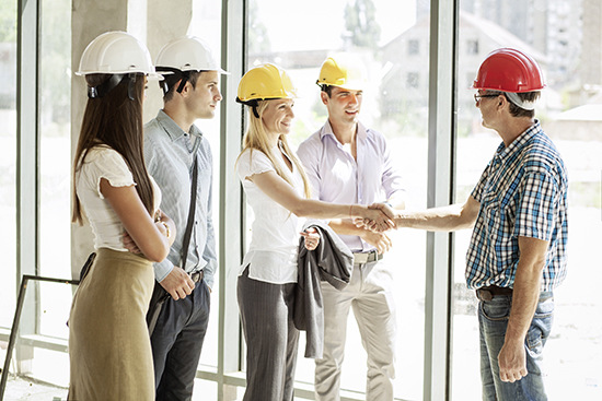 Group of architects and experts visit the work site during construction.