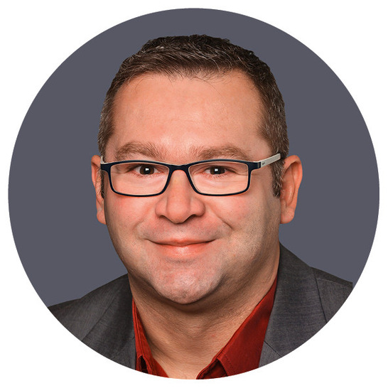 Gerne, hier ist ein optimierter, themenrelevanter und barrierefreier Alt-Text für das beschriebene Bild im oben genannten Kontext: Alt-Text: Junger SHK-Monteur mit kurzer brauner Frisur und Brille trägt einen grauen Arbeitsblazer über rotem Hemd und lächelt vor neutralem Hintergrund; symbolisiert den Berufsnachwuchs im Sanitär-, Heizungs- und Klimatechnik-Handwerk. Begründung: Dieser Alt-Text stellt klaren Bezug zur Zielgruppe (SHK-Nachwuchskräfte), ist präzise, inhaltlich relevant für die Themen der Plattform, verzichtet auf unnötige Stilbeschreibungen („smiling“, Farbe ohne Mehrwert) und unterstützt so die barrierefreie Nutzung für blinde oder sehbehinderte Fachkräfte.