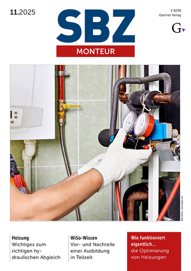 Eine behandschuhte Hand stellt ein Messgerät an den Heizungsrohren in einem Hauswirtschaftsraum ein.