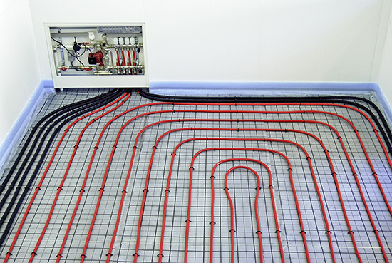 Praktikable Lösung im Aufstellraum des Verteilers: Der eigentliche Heizkreis des Raumes bleibt frei verlegt (rote Leitungen in der Mitte) die Anbindeleitungen werden in Wellrohr geführt (schwarze Leitungen am Rand)