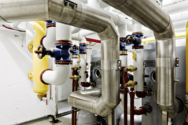 Diese hydraulische Weiche SpiroCross All in One in DN 100, in gelb﻿, links im Bild, sorgt für unabhängige ­Volumenströme