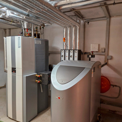 Eine montierte Hybridlösung von Wolf, rechts im Bild der Heizkessel für fossilen Brennstoff und links das Wärmepumpen-Hybridcenter mit dem Innengerät der Wärmepumpe, 300-Liter-Warmwasserspeicher und einem Trennspeicher.