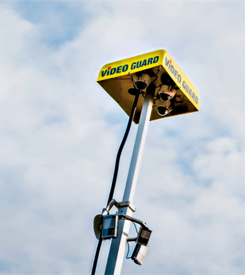 Alt-Text: „Hochwertige Überwachungskameras an einem hohen Mast, beschriftet mit ‚VIDEO GUARD‘, unter einem bewölkten Himmel – Symbol für moderne Sicherheitstechnologien im SHK-Handwerk. - © Bild: Video Guard