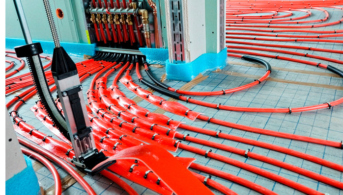 Anbindeleitungen der Fußbodenheizung – mit Dämmstreifen abgedeckt, um Hotspots im ­Verteilerbereich zu vermeiden und eine ­plane Estrichlage zu sichern.